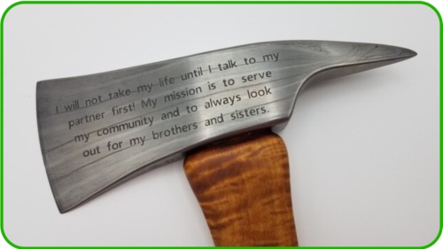 A hatchet with an engraved blade featuring the inscription: I will not take my life until I talk to my partner first. My mission is to help my community and always look out for my brothers and sisters.
